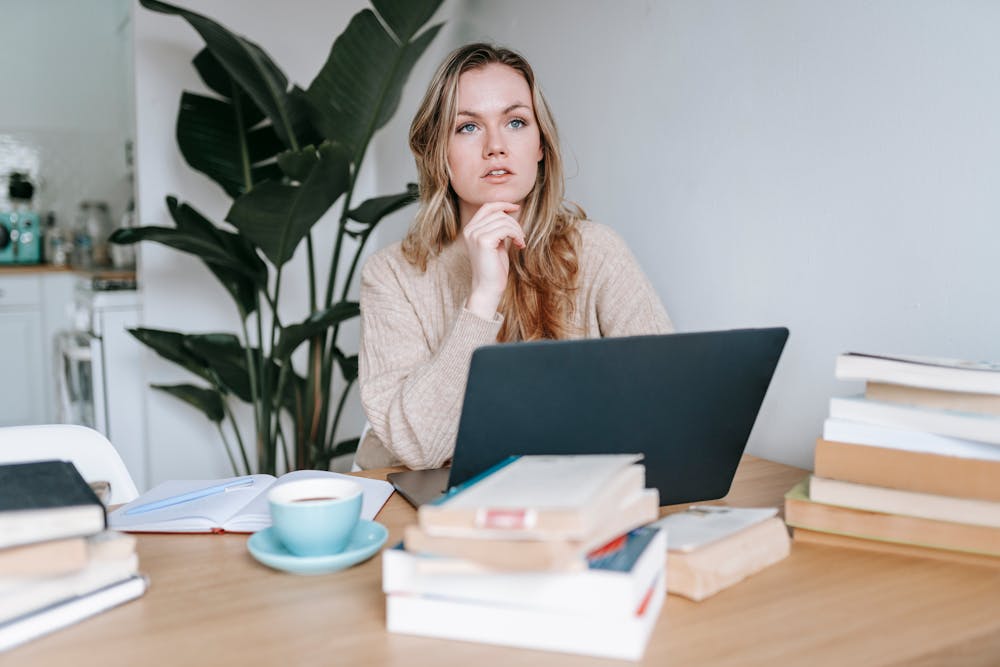 A person using a laptop to do research and thinking about what questions to ask before choosing a media conversion service