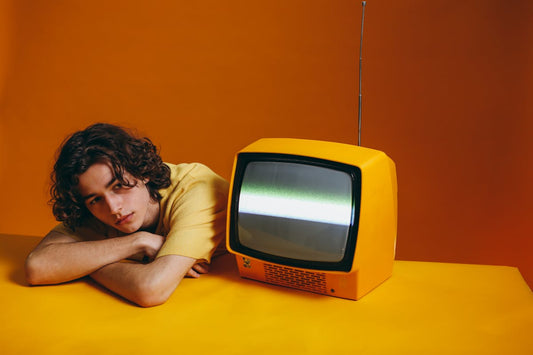 Guy In Yellow Shirt Sitting Beside A Yellow Classic TV Wondering What Was Before Betamax